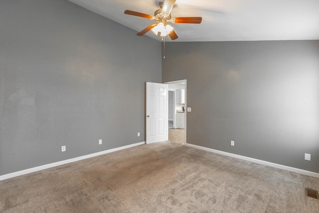 carpeted empty room featuring a ceiling fan, visible vents, high vaulted ceiling, and baseboards