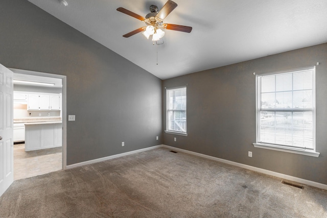 unfurnished room with light carpet, a ceiling fan, visible vents, and baseboards