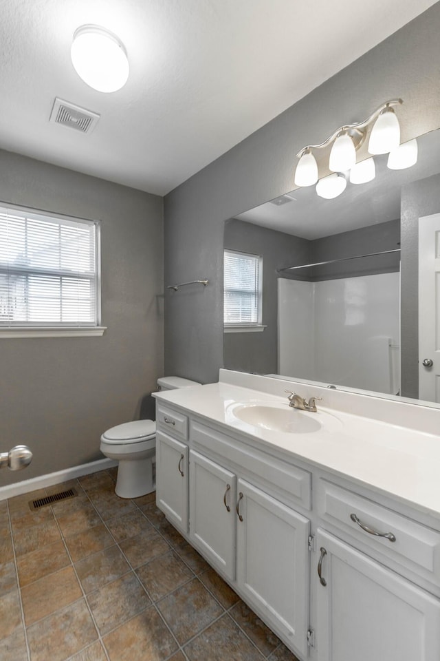 full bathroom featuring toilet, a wealth of natural light, and visible vents