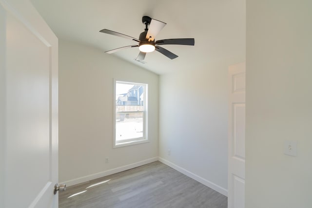 unfurnished room with lofted ceiling, visible vents, baseboards, a ceiling fan, and light wood-style floors