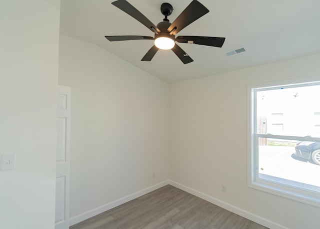 spare room with a ceiling fan, light wood-type flooring, visible vents, and baseboards