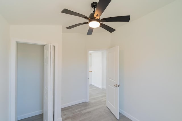 unfurnished bedroom featuring a ceiling fan, light wood-style flooring, and baseboards