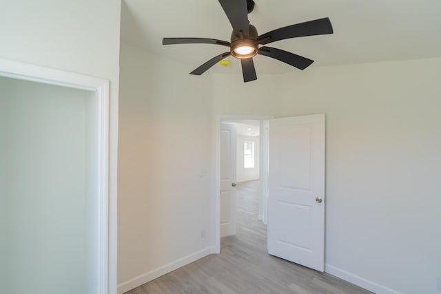 unfurnished room featuring light wood-type flooring, a ceiling fan, and baseboards