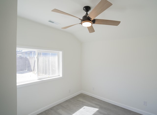 unfurnished room with lofted ceiling, light wood finished floors, baseboards, and visible vents