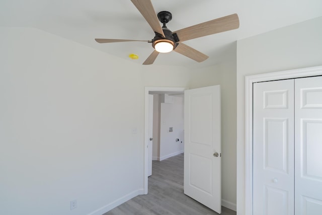 unfurnished bedroom with light wood-style floors, a closet, baseboards, and a ceiling fan