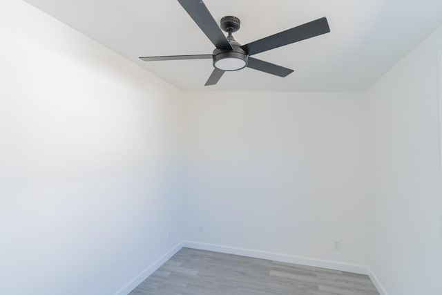 spare room with a ceiling fan, light wood-style flooring, and baseboards