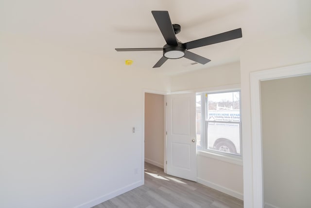 unfurnished room featuring ceiling fan, light wood-style floors, visible vents, and baseboards