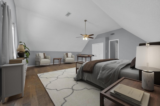 bedroom with lofted ceiling, visible vents, baseboards, and hardwood / wood-style flooring