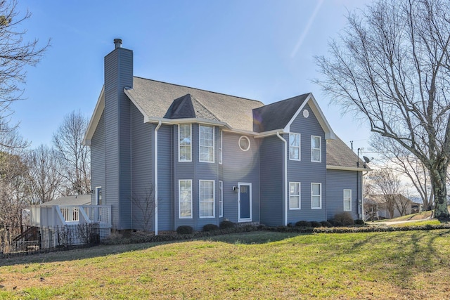 view of front of home featuring a chimney, fence, a front lawn, and roof with shingles