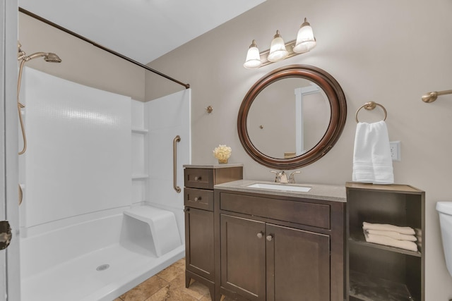 bathroom with toilet, walk in shower, and vanity