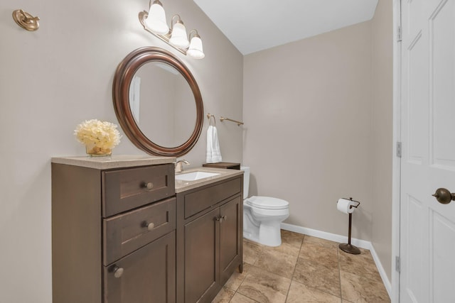 bathroom featuring vanity, toilet, and baseboards