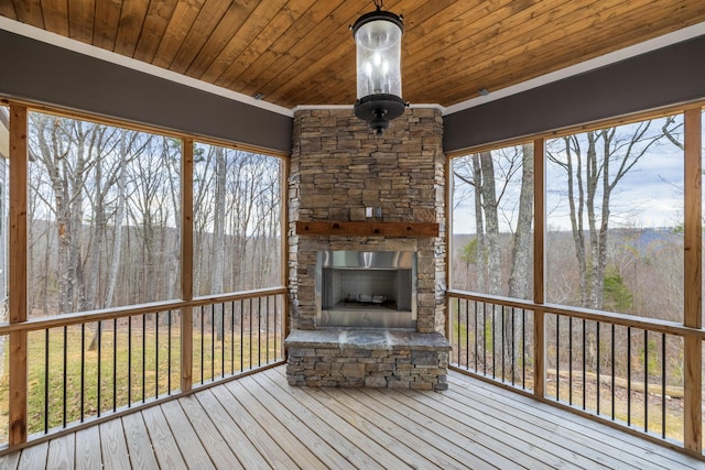 wooden terrace featuring an outdoor stone fireplace