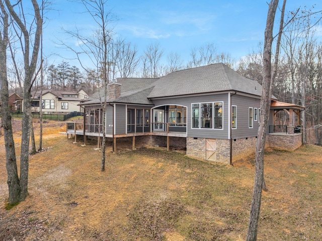 back of house with roof with shingles, a chimney, a lawn, a sunroom, and crawl space