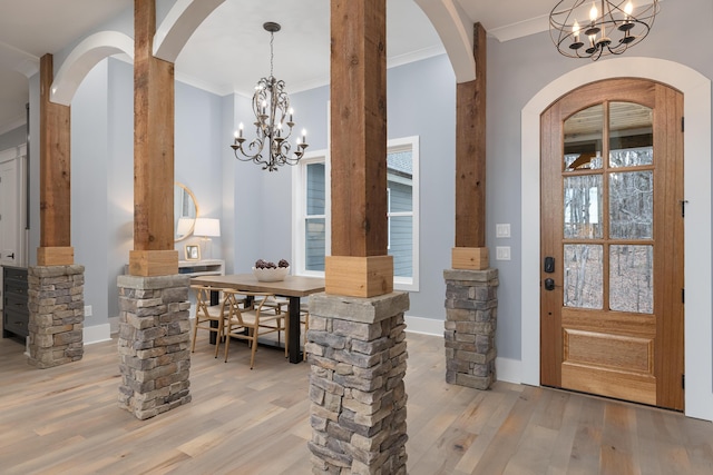 interior space with light wood-style floors, baseboards, ornamental molding, and a notable chandelier