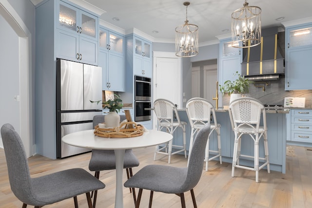 dining space featuring crown molding and light wood-style flooring