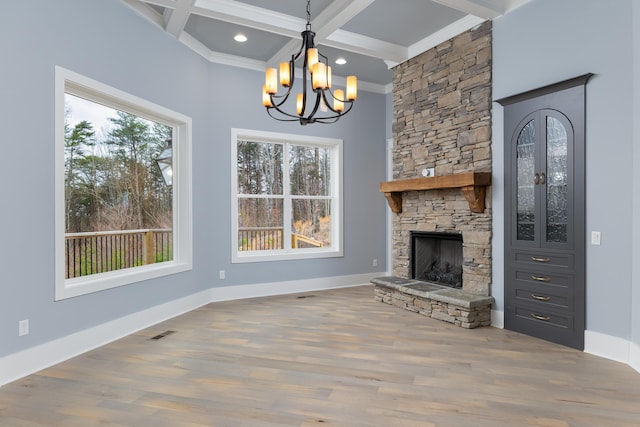 unfurnished living room featuring a fireplace, visible vents, wood finished floors, coffered ceiling, and beamed ceiling