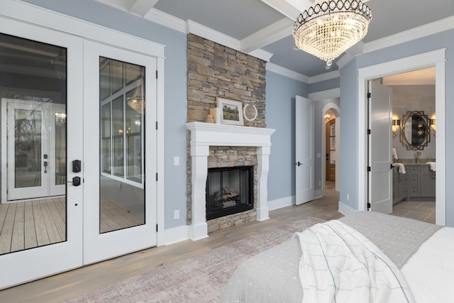 bedroom featuring a fireplace, wood finished floors, access to outside, ornamental molding, and french doors