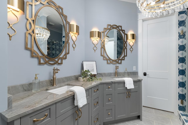 full bathroom with double vanity, an inviting chandelier, tile patterned flooring, and a sink