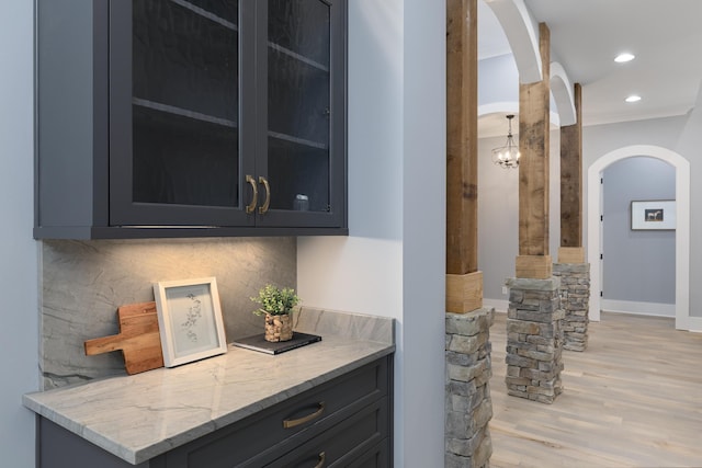 bar with tasteful backsplash, arched walkways, baseboards, light wood-style floors, and recessed lighting