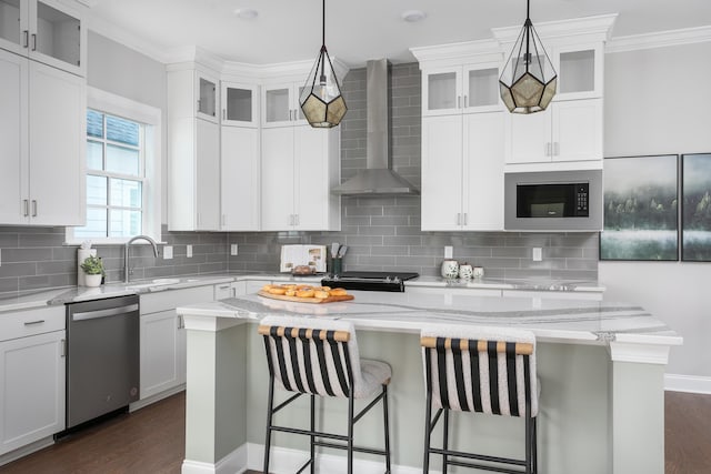 kitchen with ornamental molding, a center island, built in microwave, wall chimney range hood, and stainless steel dishwasher