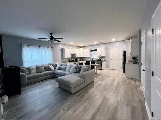 living room featuring light wood-style floors, recessed lighting, ceiling fan, and baseboards