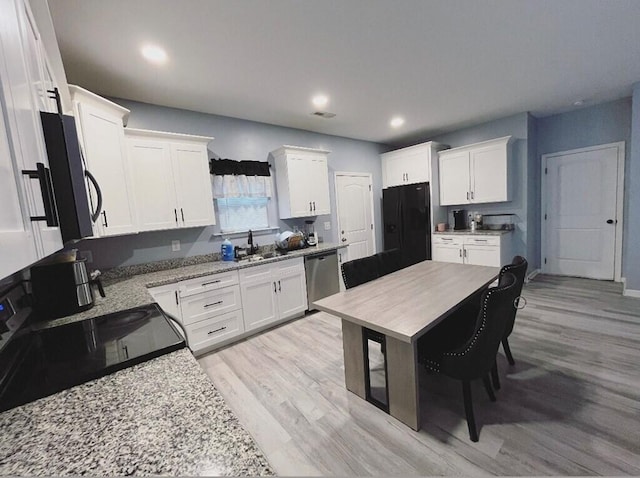 kitchen with white cabinets, a sink, and black appliances