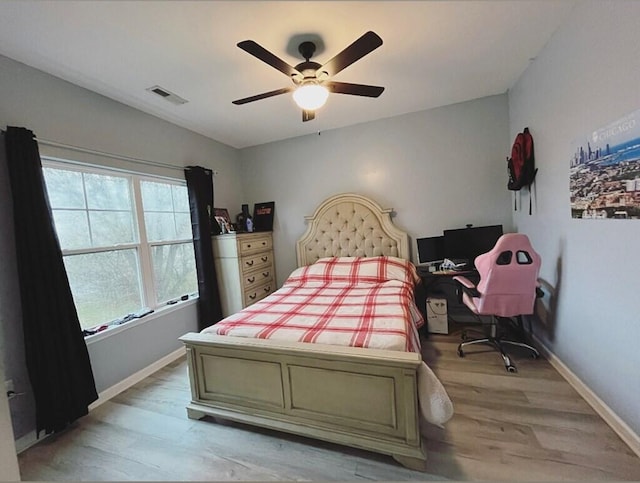 bedroom with a ceiling fan, visible vents, light wood-style flooring, and baseboards