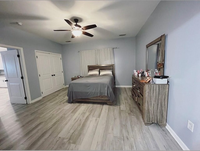 bedroom with ceiling fan, visible vents, light wood-style flooring, and baseboards