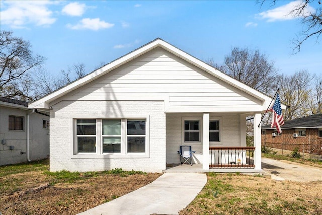 bungalow-style home with brick siding and covered porch