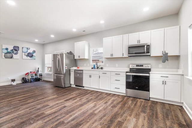 kitchen with a sink, light countertops, dark wood finished floors, and stainless steel appliances