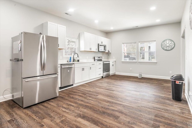 kitchen with visible vents, light countertops, appliances with stainless steel finishes, white cabinets, and dark wood-style flooring