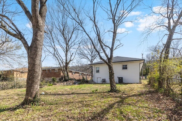 view of yard featuring central AC unit and fence