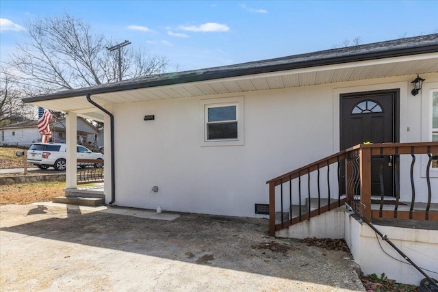 view of exterior entry featuring stucco siding