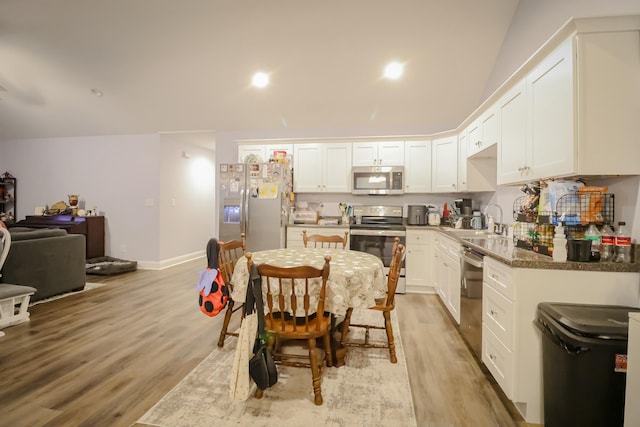 kitchen with appliances with stainless steel finishes, white cabinetry, a sink, and light wood-style flooring