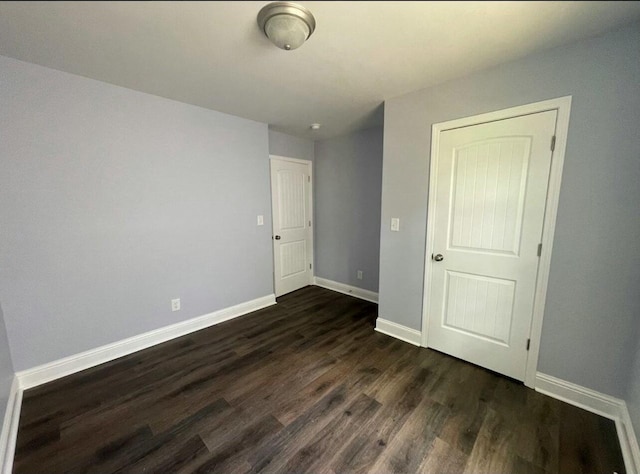 unfurnished bedroom featuring dark wood finished floors and baseboards