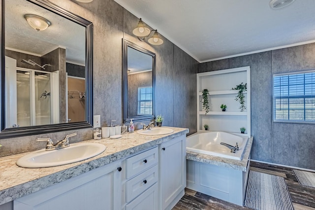 full bathroom with a bath, double vanity, visible vents, and a sink