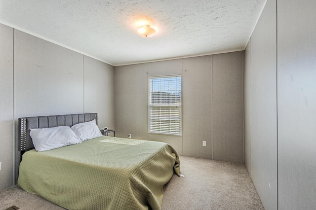 bedroom with carpet floors and a textured ceiling