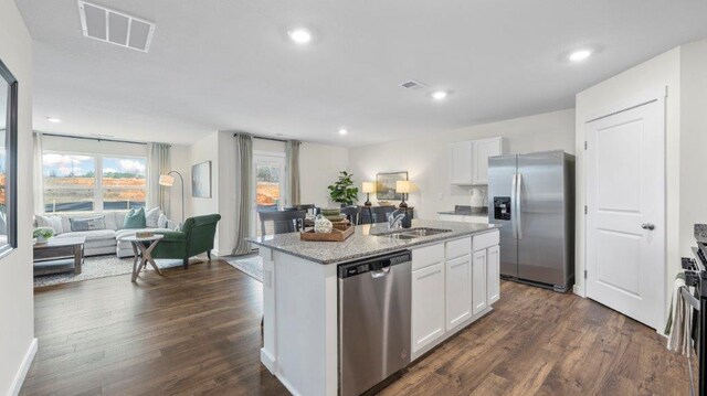 kitchen with stainless steel appliances, a sink, visible vents, white cabinetry, and open floor plan