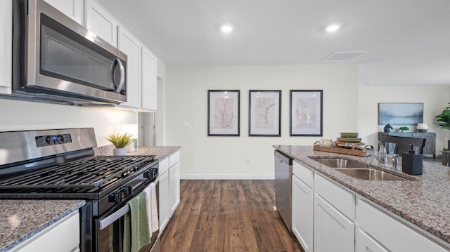 kitchen featuring visible vents, white cabinets, appliances with stainless steel finishes, light stone counters, and a sink