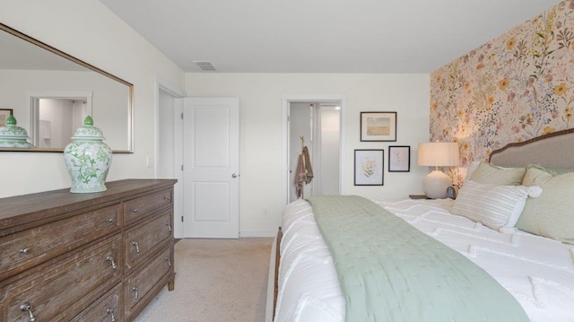 bedroom with visible vents and light colored carpet