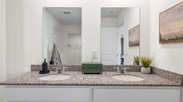 bathroom featuring visible vents, a sink, and double vanity