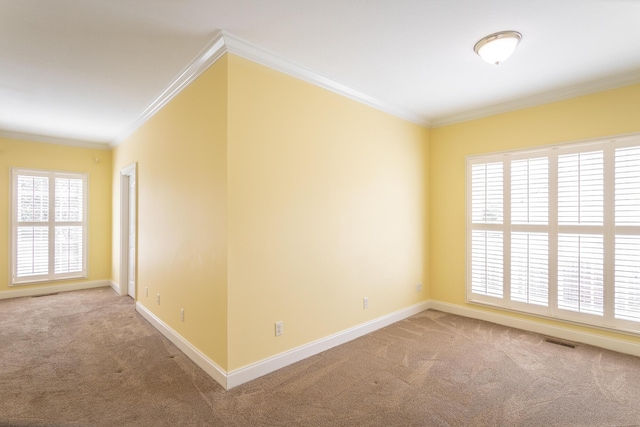 carpeted empty room featuring baseboards, visible vents, and ornamental molding