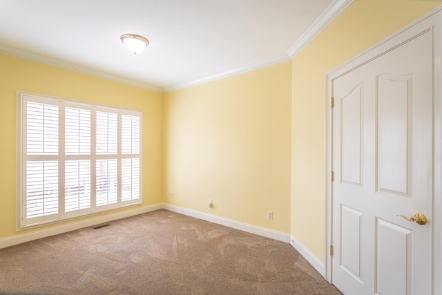 spare room featuring crown molding, carpet flooring, visible vents, and baseboards