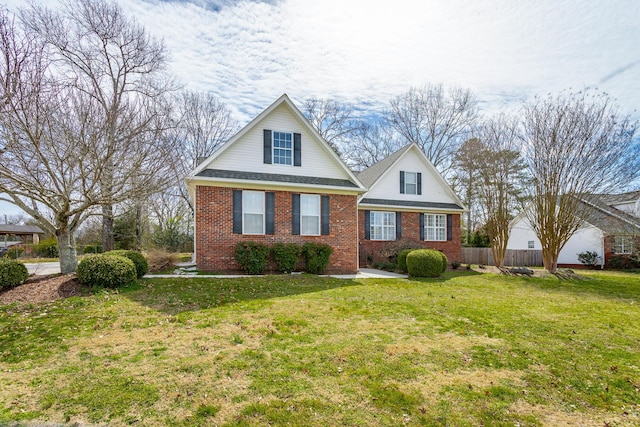 view of front of property with brick siding, roof with shingles, a front yard, and fence