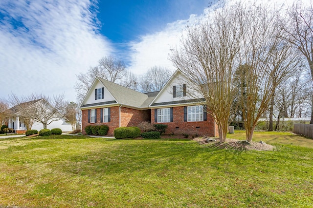 view of front facade with brick siding, fence, a front yard, roof with shingles, and crawl space