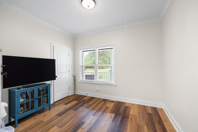 unfurnished living room with ornamental molding, wood finished floors, and attic access