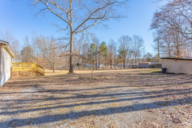 view of yard featuring an outdoor structure, stairway, and a wooden deck