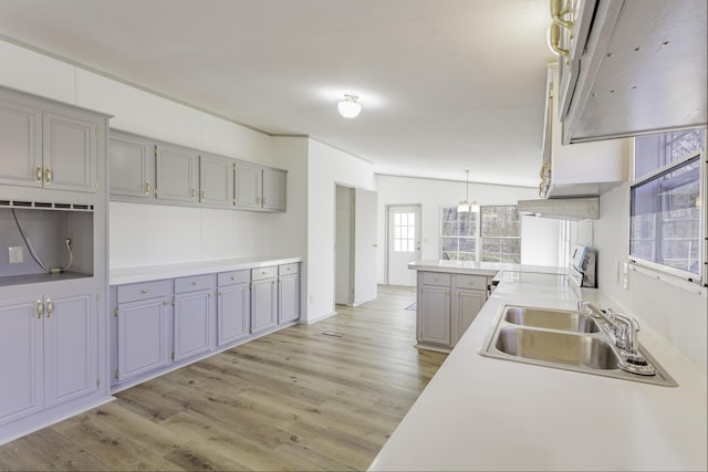 kitchen featuring light wood-style floors, stove, a sink, and gray cabinetry