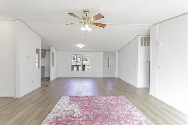 unfurnished living room with wood finished floors, visible vents, and a ceiling fan