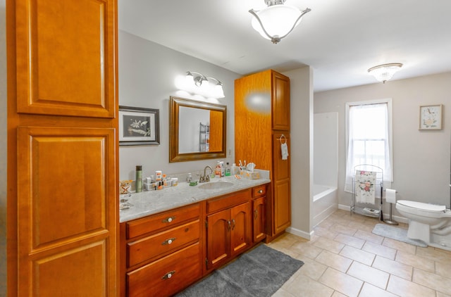 bathroom featuring tile patterned flooring, a washtub, toilet, vanity, and baseboards